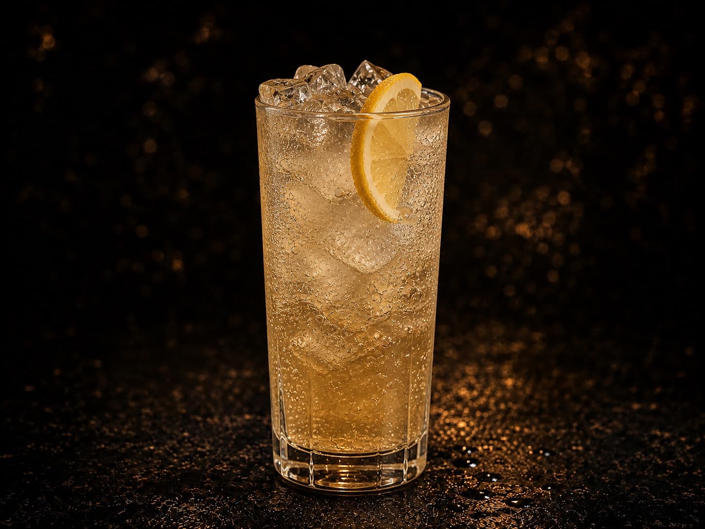 Amaretto Fizz i ett highballglas med is, ljus bubblig drink och citron.