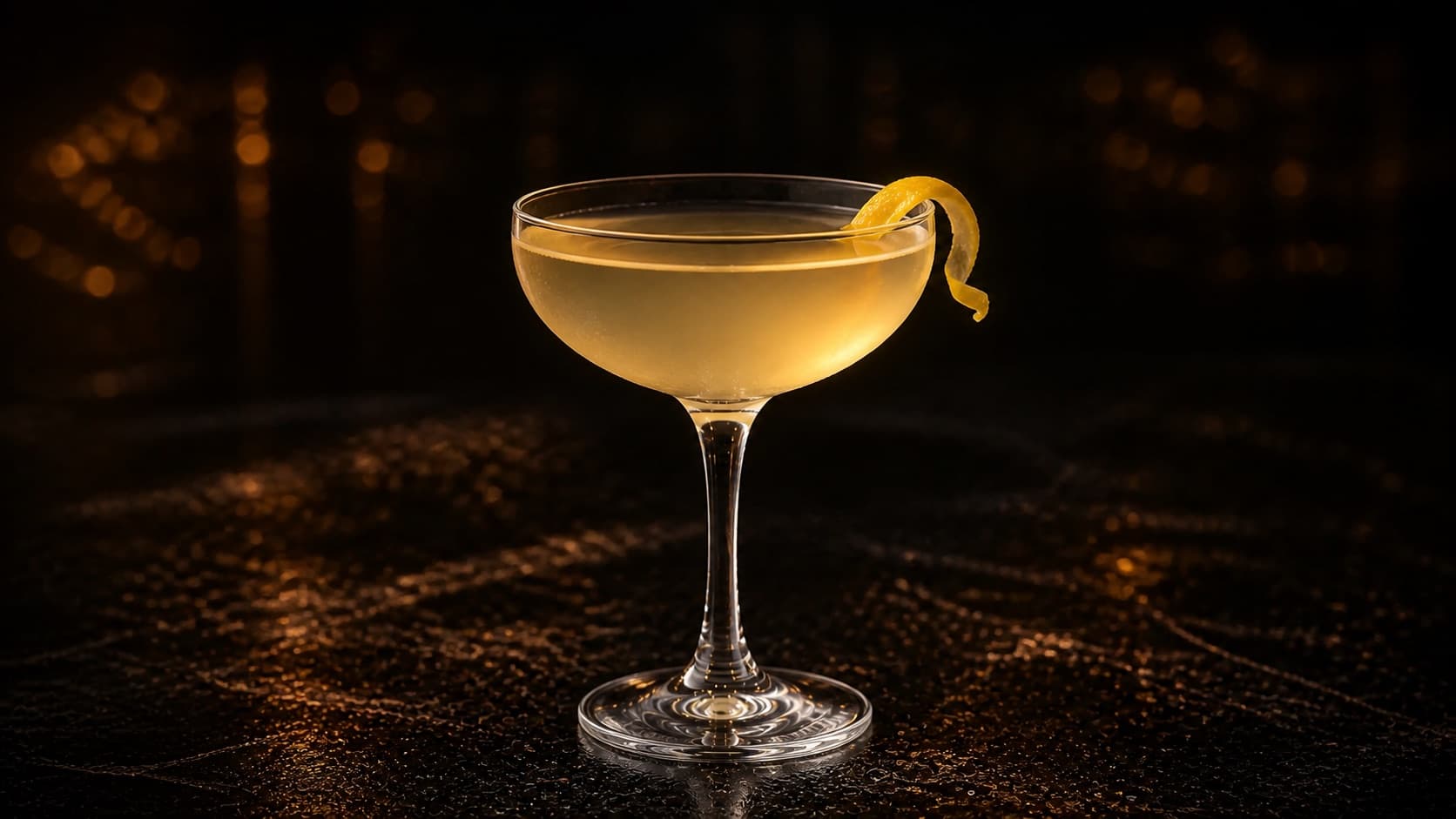 Bee's Knees i coupeglas med klar ljusgul cocktail och liten citronzest.
