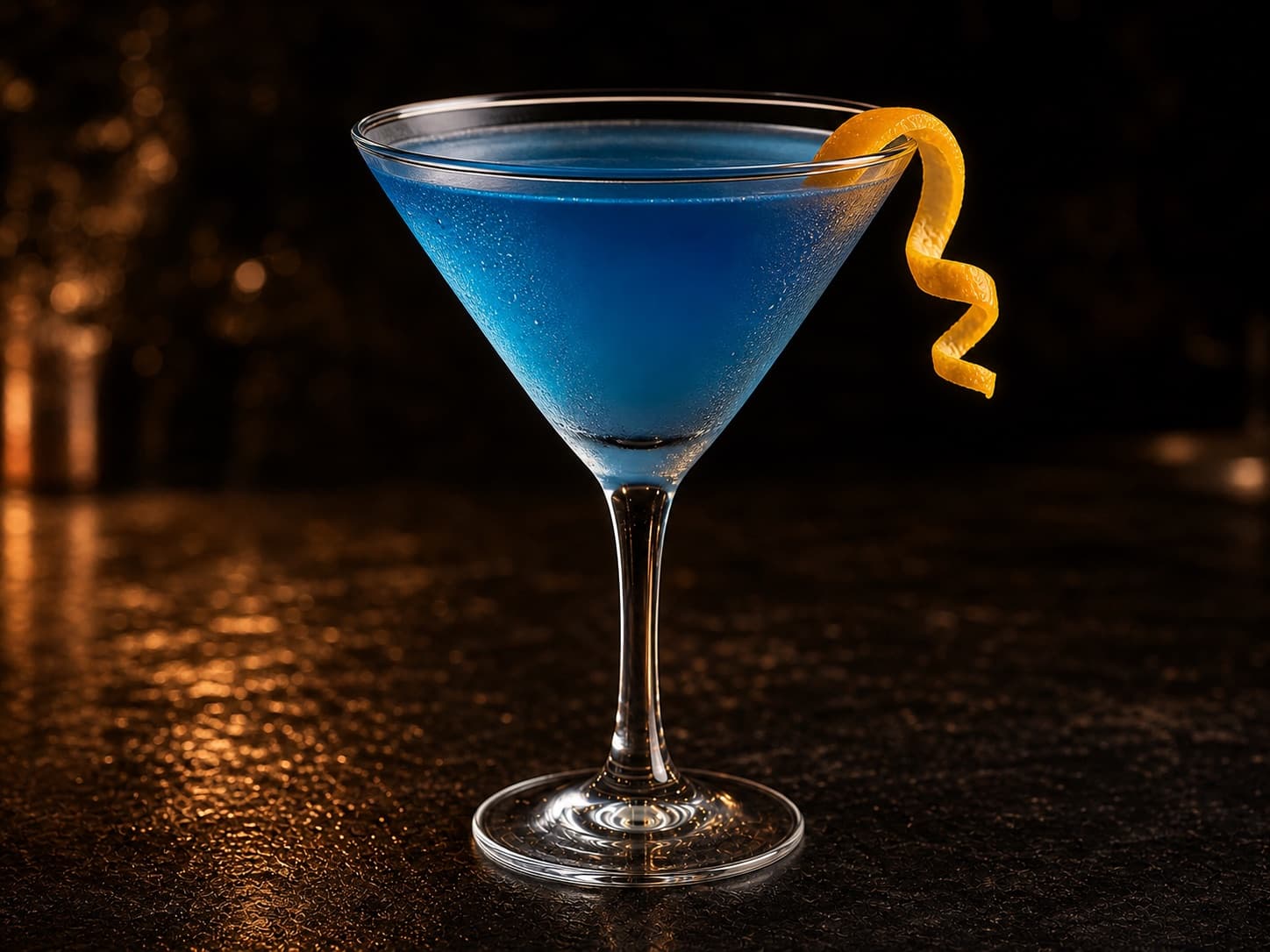 Blue Lady i ett kylt martiniglas med klar blå drink och apelsinzest.