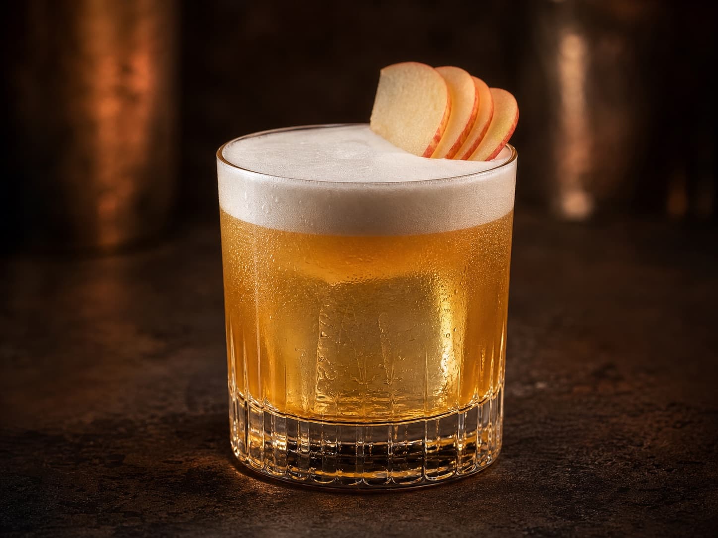 Calvados Sour i ett lågt glas med is, ljust skum och en tunn äppelskiva.