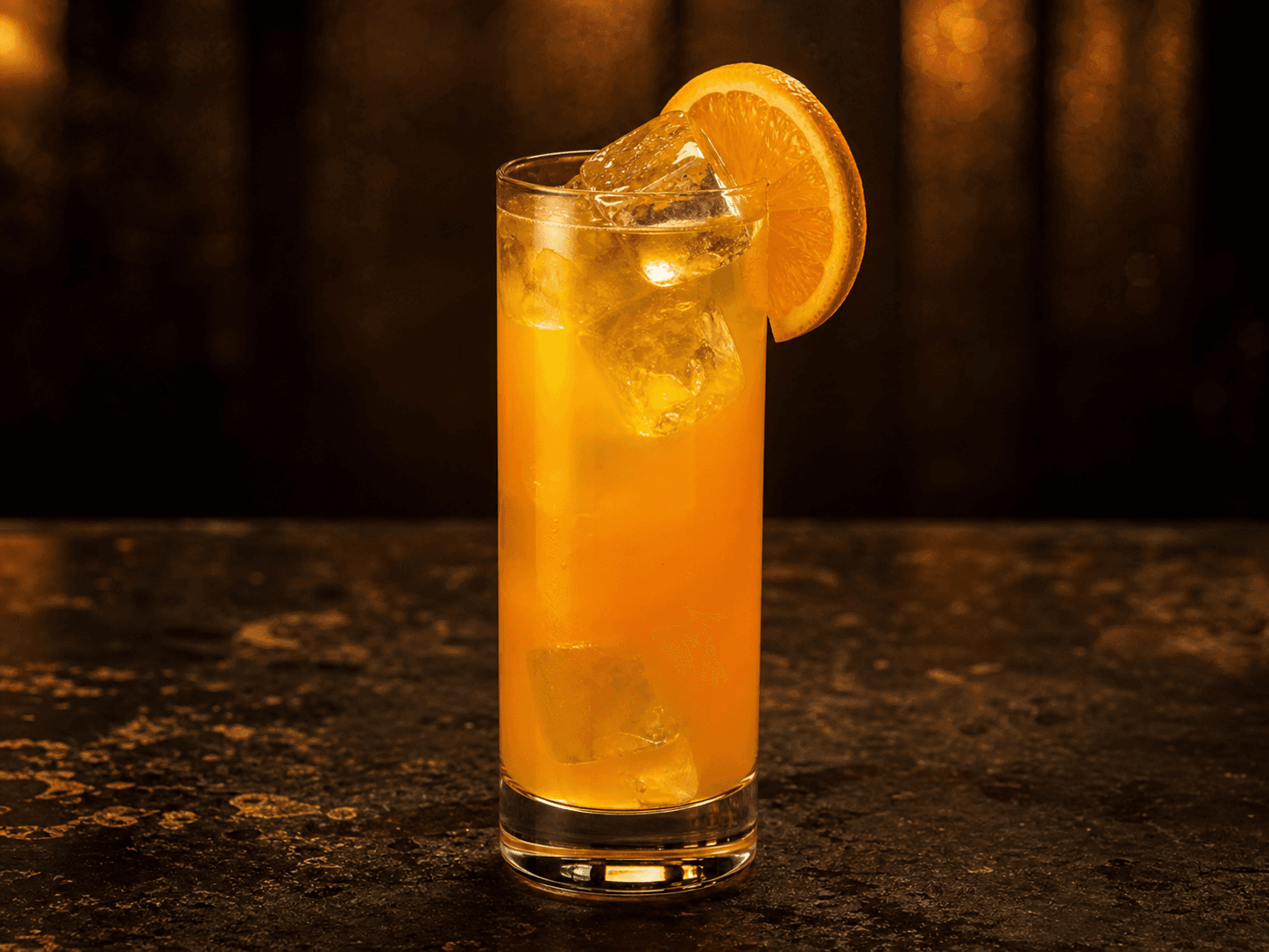 Harvey Wallbanger i ett highballglas med orange drink, is och en apelsinskiva.