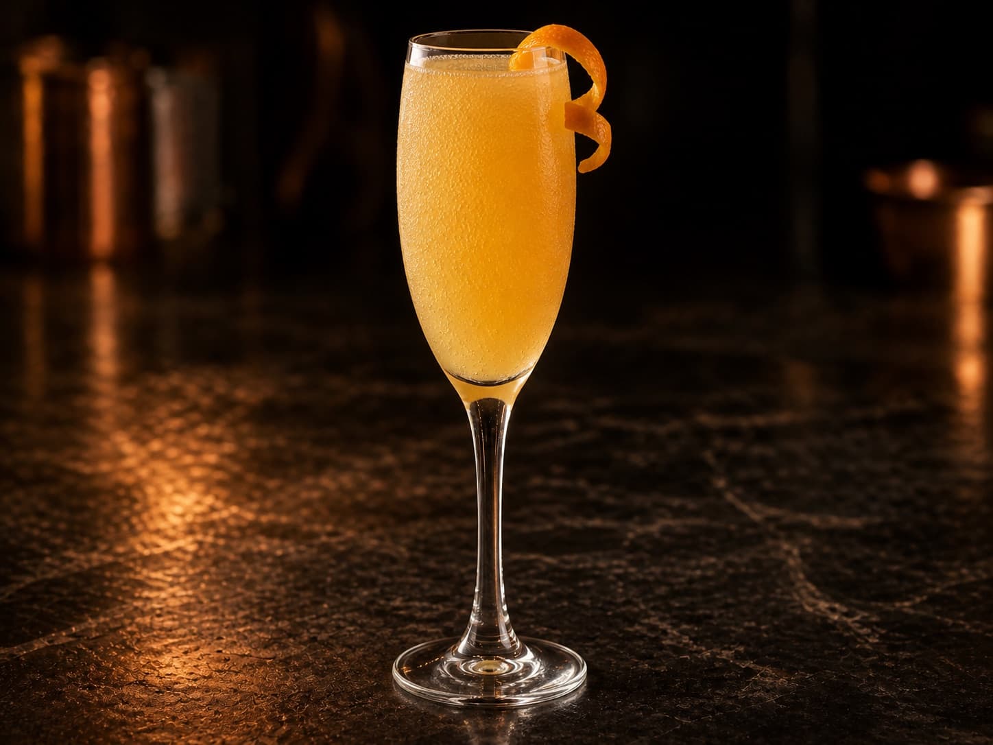 Mimosa i ett champagneglas med ljust orange, bubblig drink.