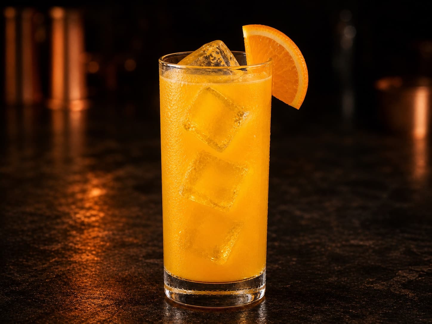 Screwdriver i ett högt glas med is och en skiva apelsin.