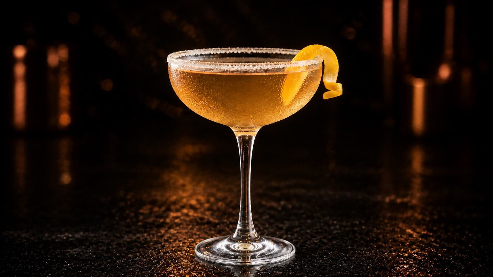 Sidecar i ett kylt coupeglas med gyllene cocktail, lätt sockerkant och en kort apelsintwist.