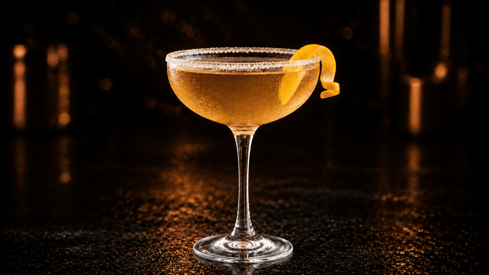 Sidecar i ett kylt coupeglas med gyllene cocktail, lätt sockerkant och en kort apelsintwist.