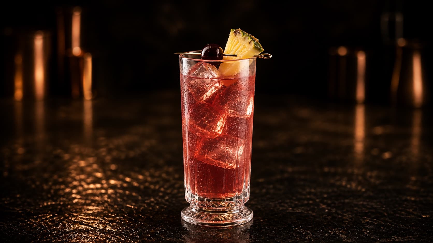 Singapore Sling i ett högt glas med rosa-röd cocktail, is, ananas och cocktailkörsbär.