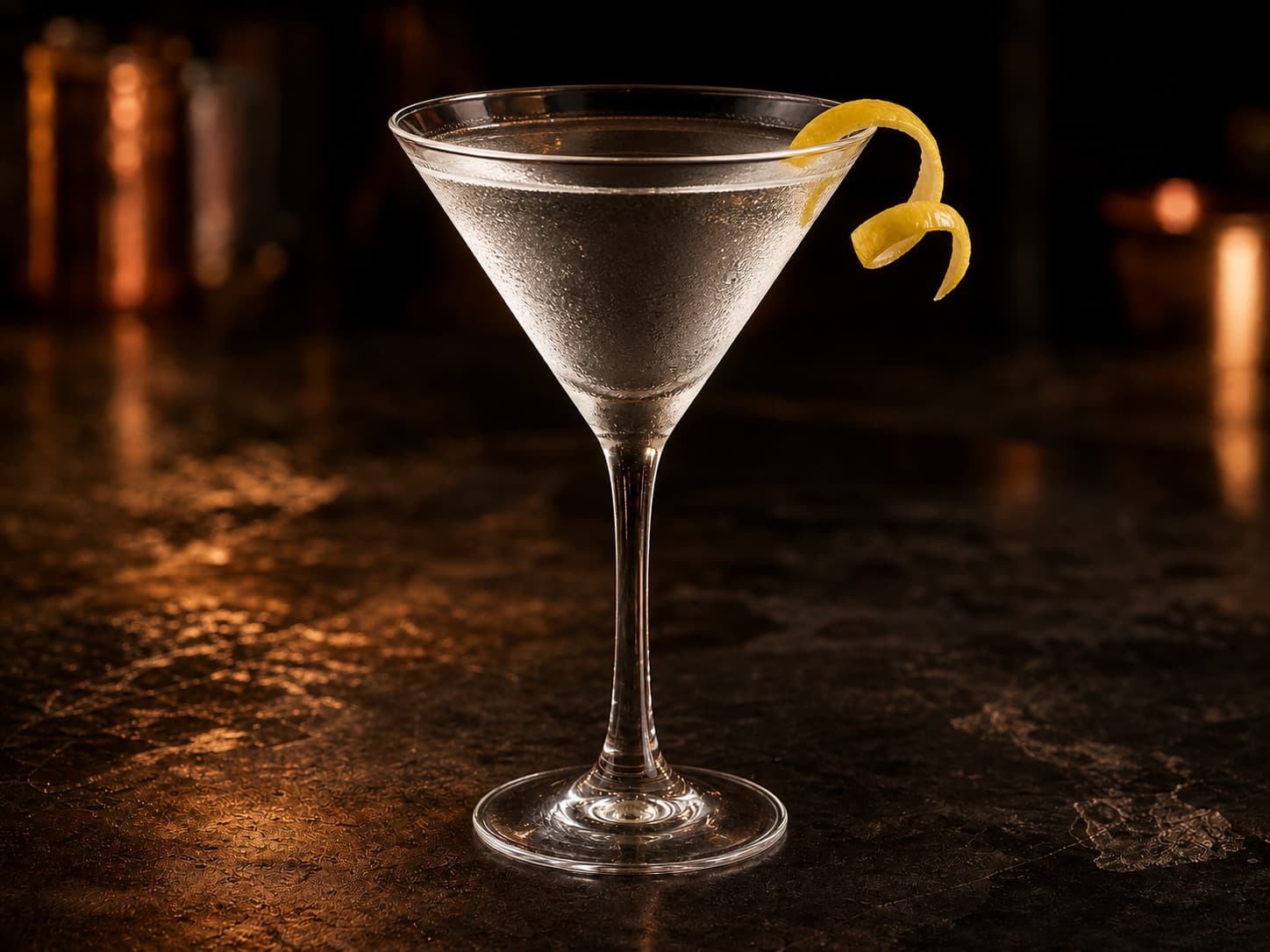 Vodka Martini i ett kylt martiniglas med klar cocktail och en tunn citronzest.
