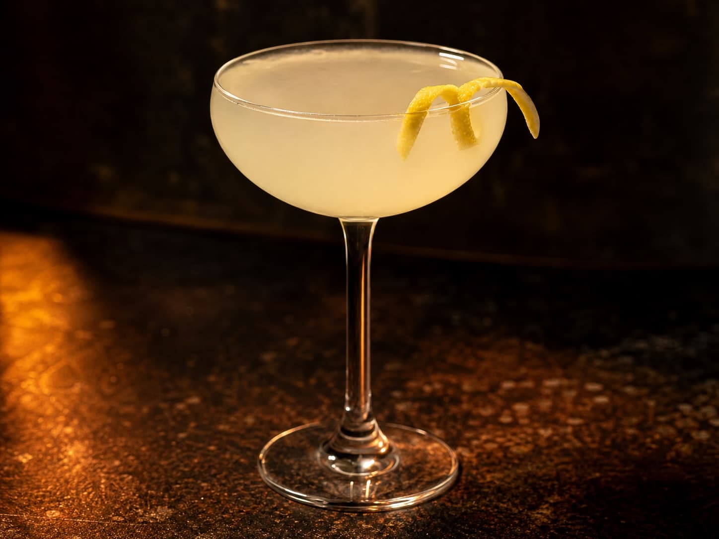 White Lady i ett kylt coupeglas med klar ljus cocktail och citronzest.